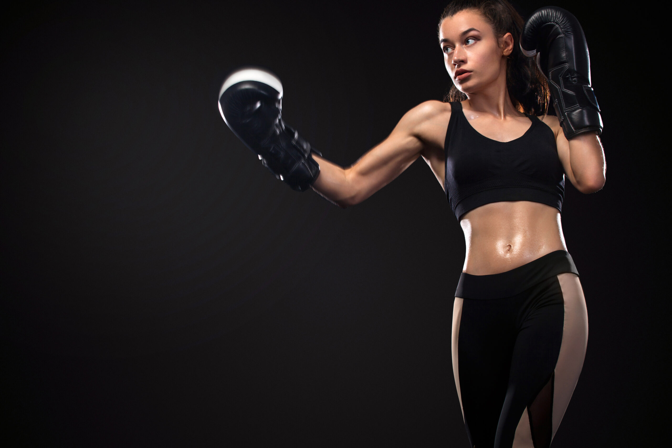 Street fighter fighting in boxing gloves. Isolated on black background with copy Space. Action shot. Sport concept.